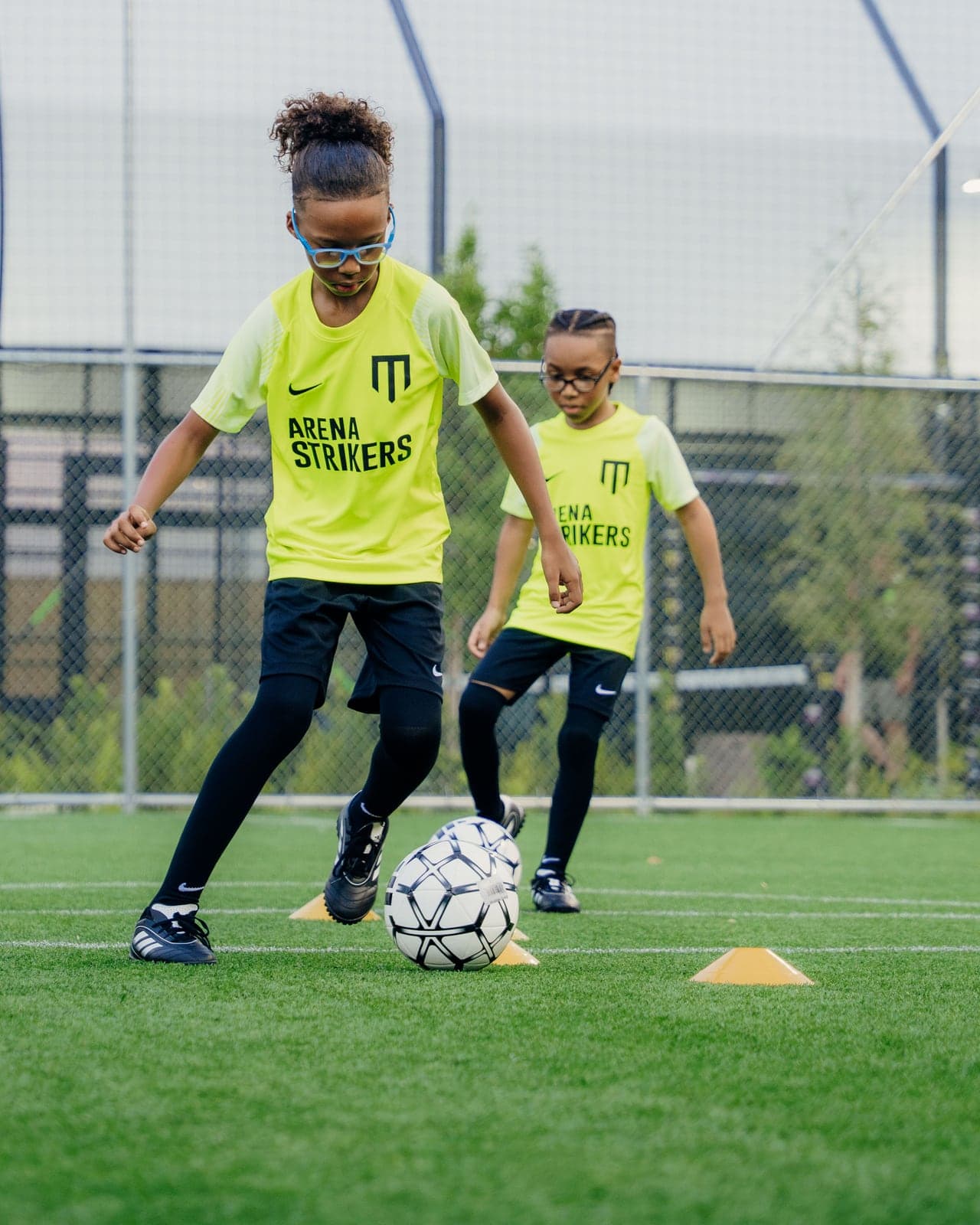 Two Arena Strikers players dribbling through cones at a training session at Arena SSC Wynwood, Miami