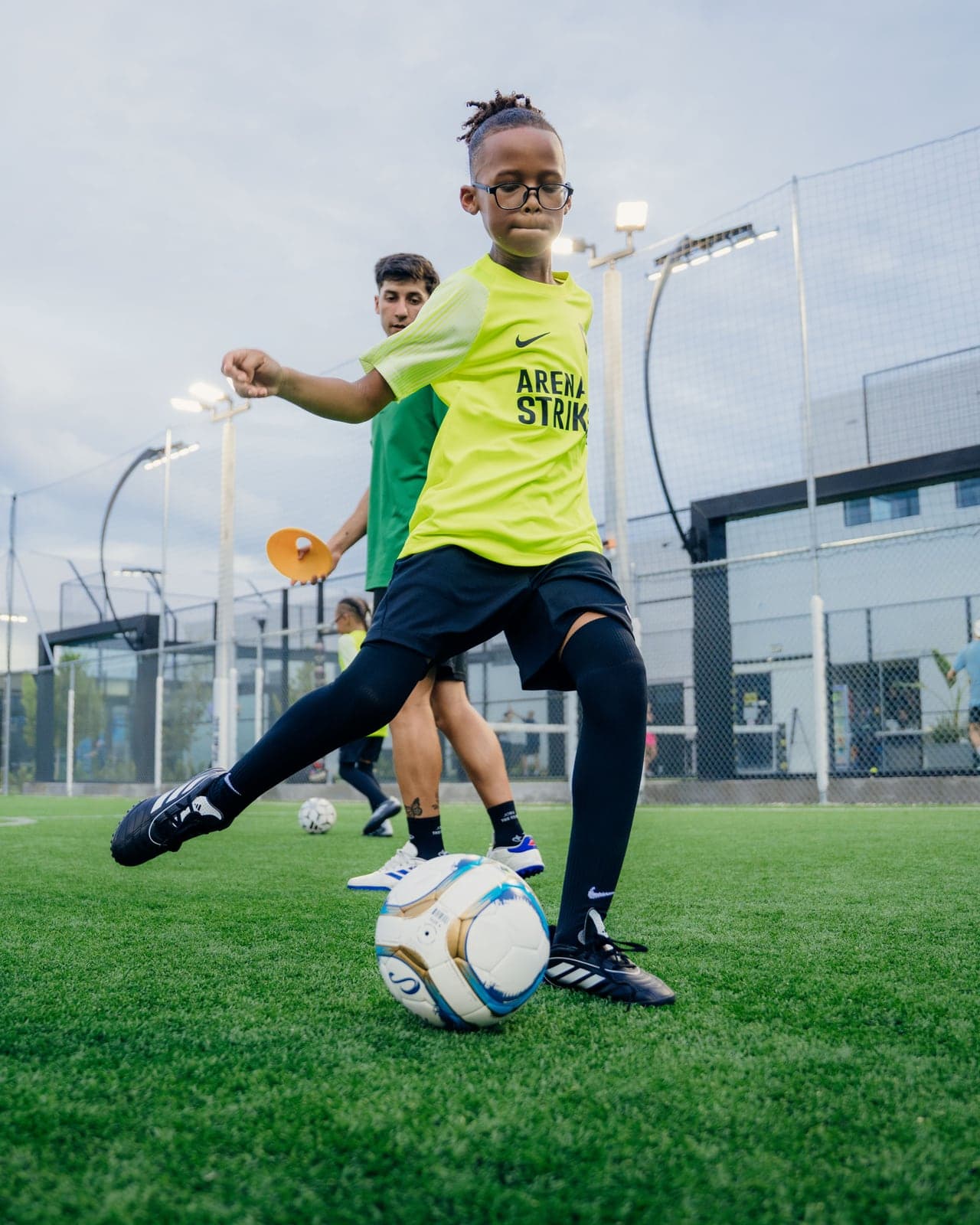 Arena Strikers player in the lime kit striking the ball during training at Arena SSC Wynwood, Miami