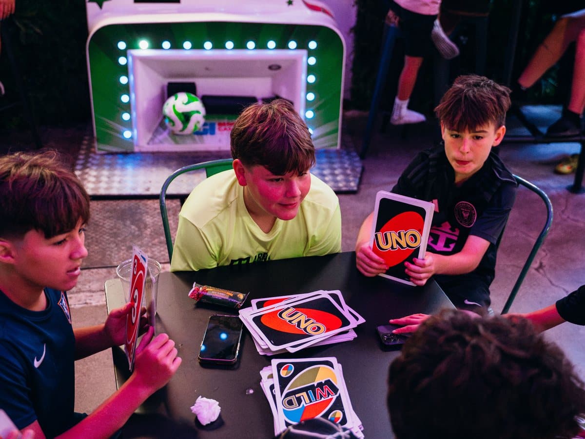 Campers playing a card game around a table during a break at camp