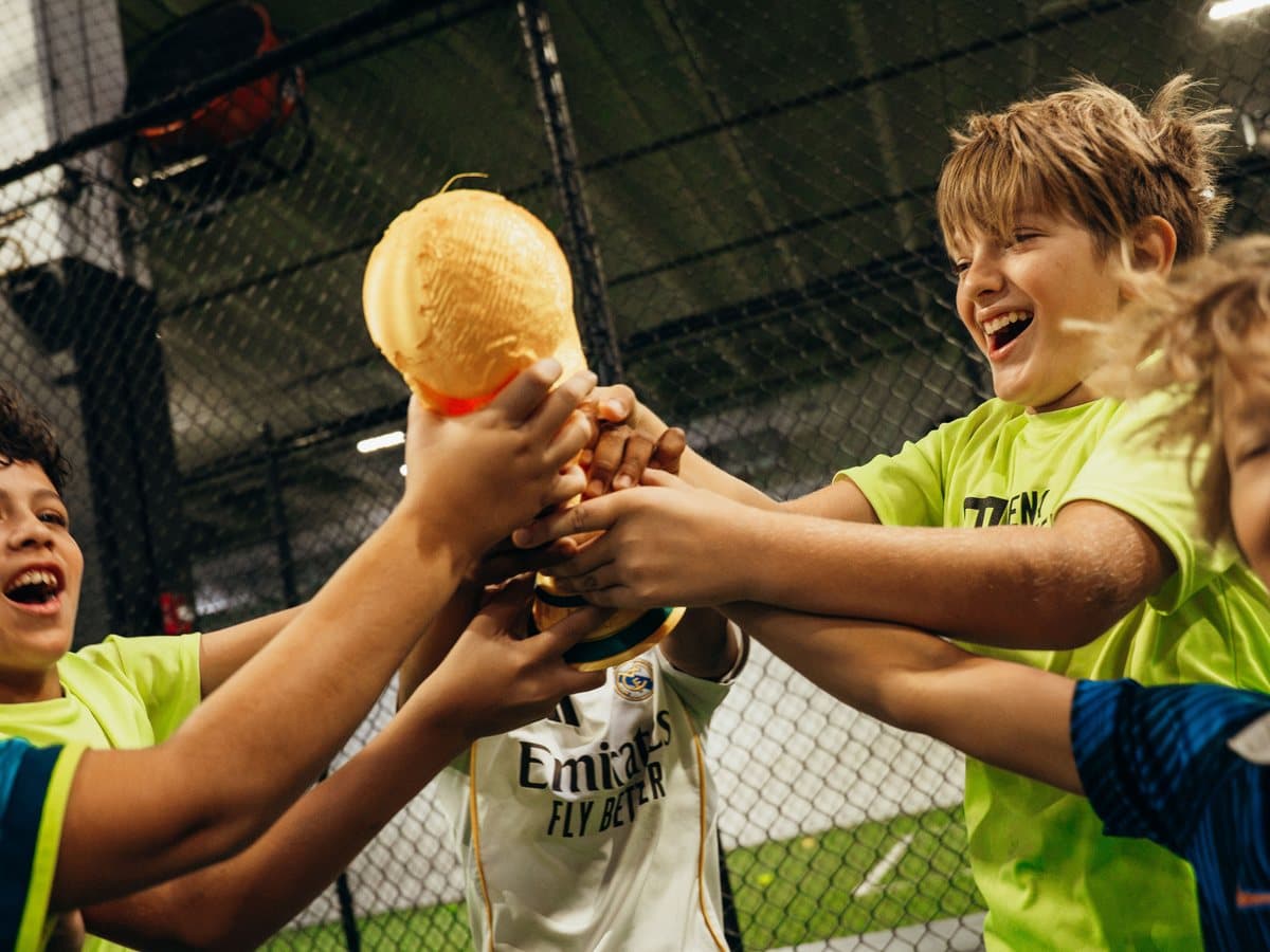 Campers laughing and lifting a trophy together after winning a camp challenge