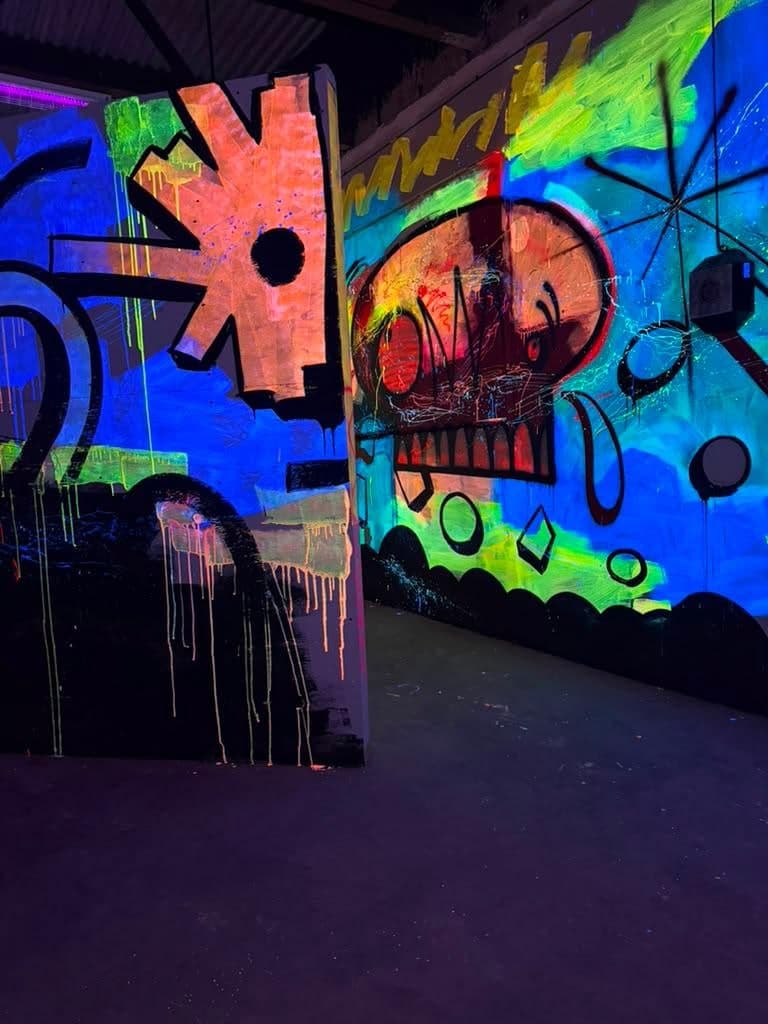 The laser tag arena at Arena SSC Wynwood: fluorescent graffiti walls and barriers under blacklight (1 of 9)