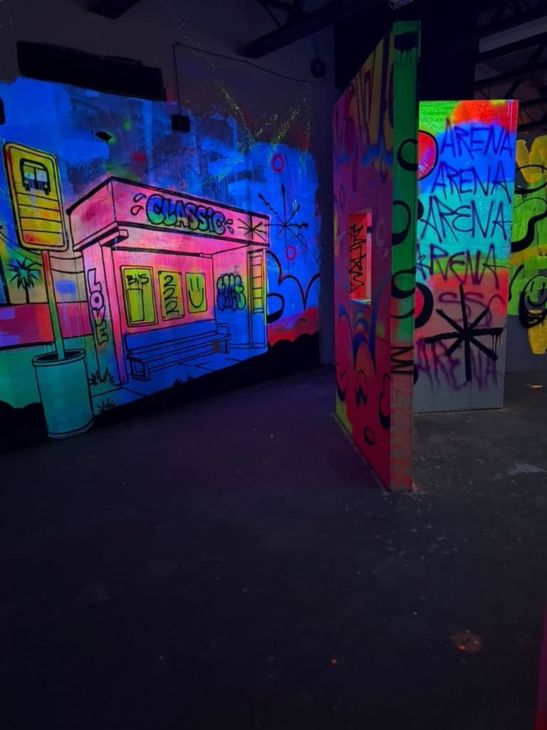 The laser tag arena at Arena SSC Wynwood: fluorescent graffiti walls and barriers under blacklight (4 of 9)