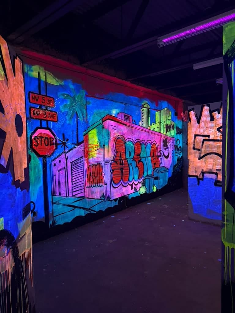 The laser tag arena at Arena SSC Wynwood: fluorescent graffiti walls and barriers under blacklight (2 of 9)