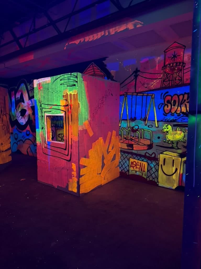 The laser tag arena at Arena SSC Wynwood: fluorescent graffiti walls and barriers under blacklight (5 of 9)